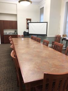 The community room features two long conference tables seating 14